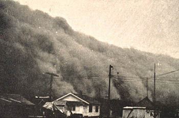 picture of a dust storm from the dust bowl overwhelming a town